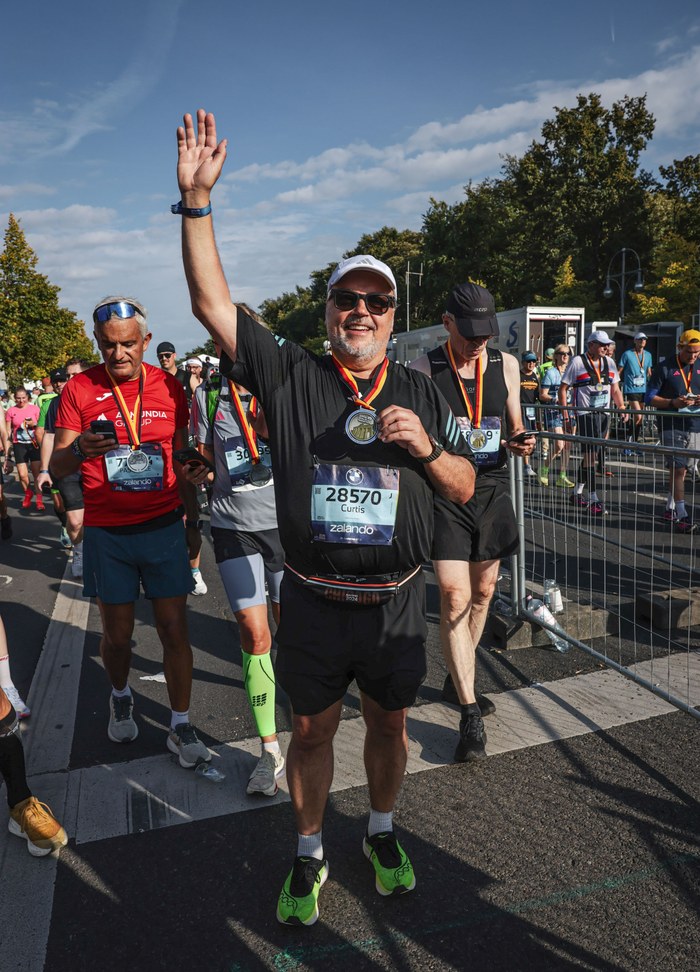 Curtis celebrating with his medal at the Berlin Marathon
