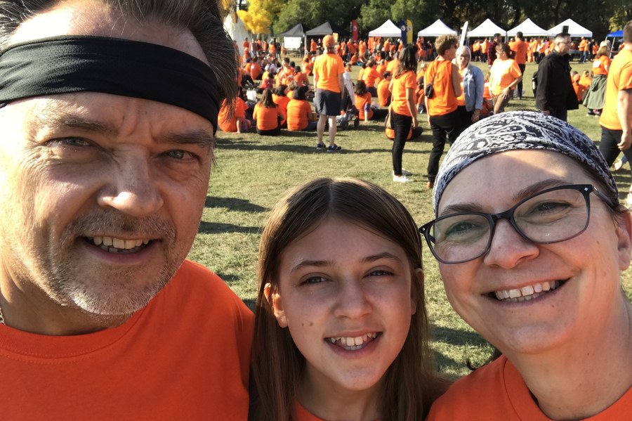 Curtis with family at a race in matching orange shirts